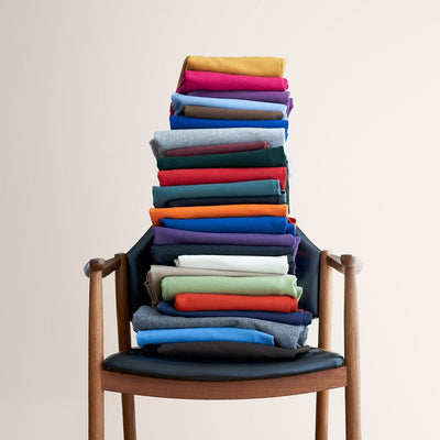 Ulltyg i flera färger av 100% filtad merinoull staplad på en stol